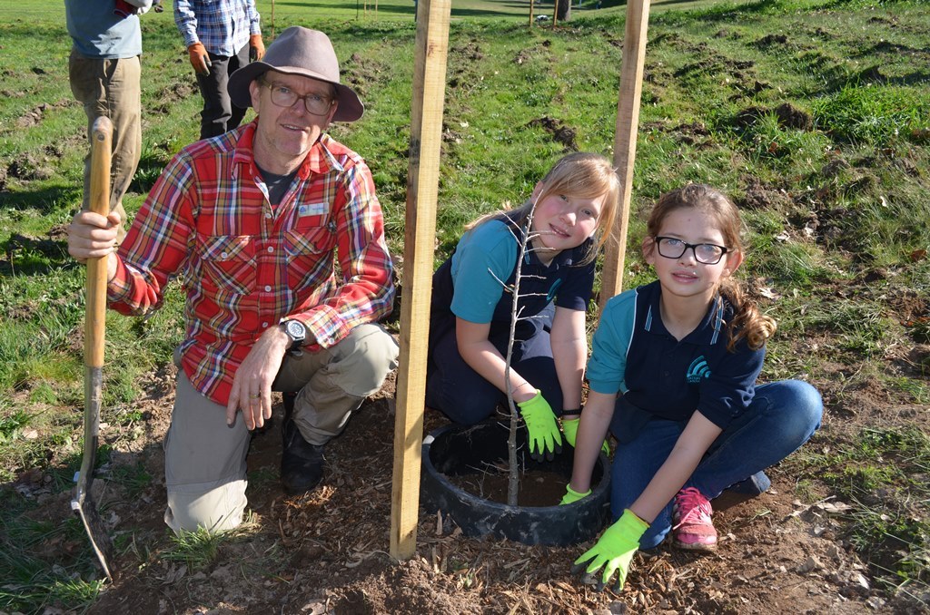 Students from Winters Flat Primary School and garden specialist Terry Willis plant a seedling